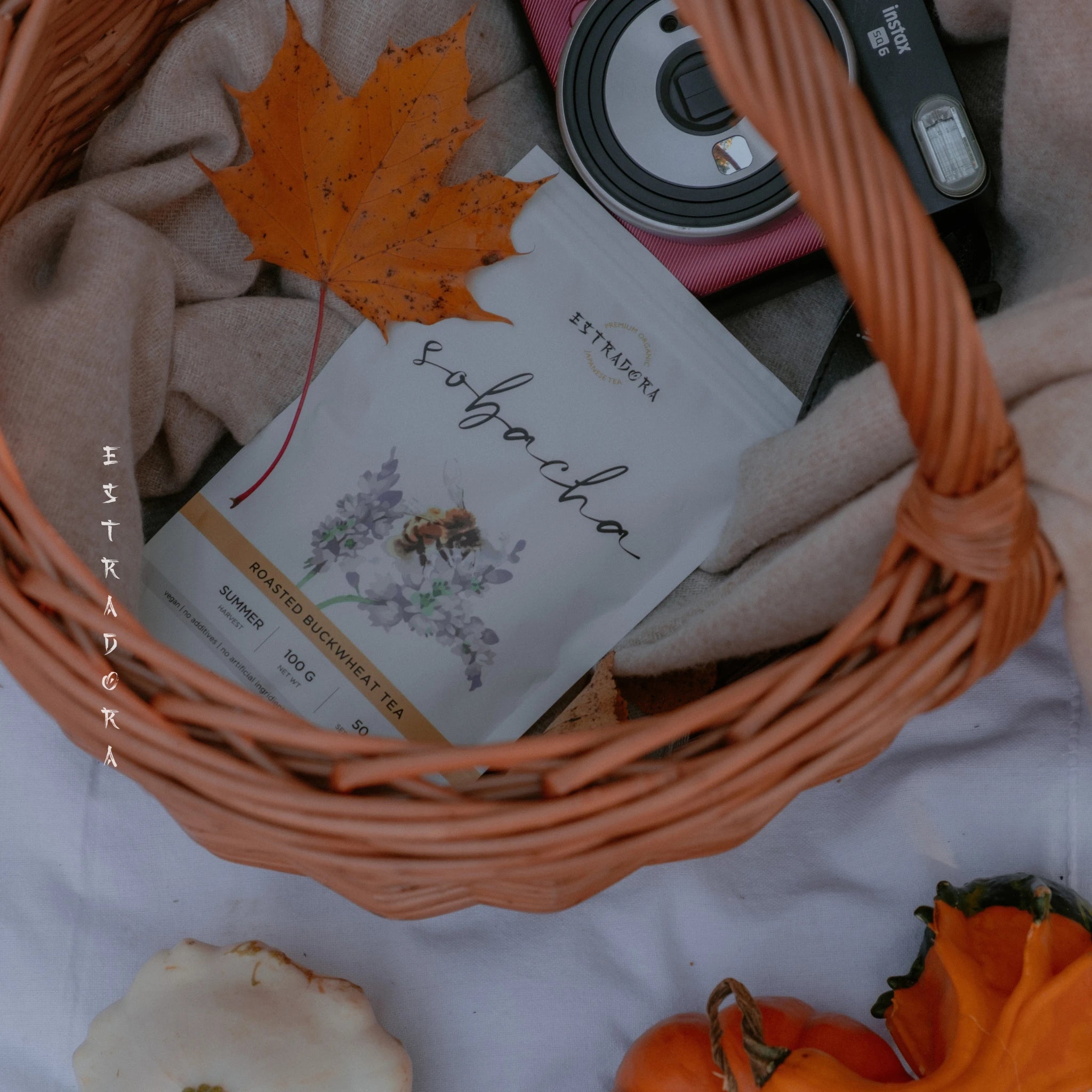 Sobacha roasted buckwheat tea package in wicker basket with autumn leaves and seasonal decorations