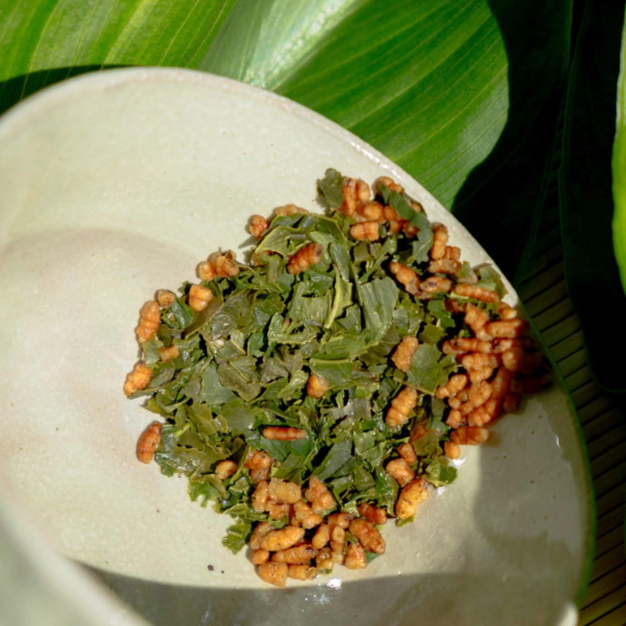 Loose leaf Japanese Genmaicha tea blend with roasted brown rice, close-up on ceramic plate, natural light