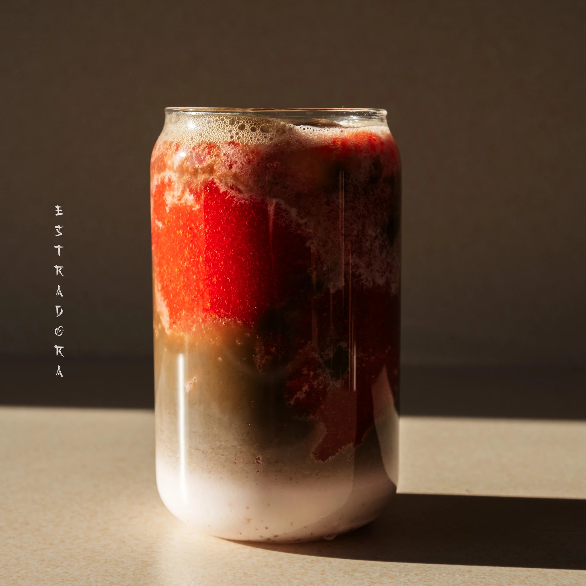 Iced hojicha latte with strawberry puree – layered Japanese roasted green tea drink in glass