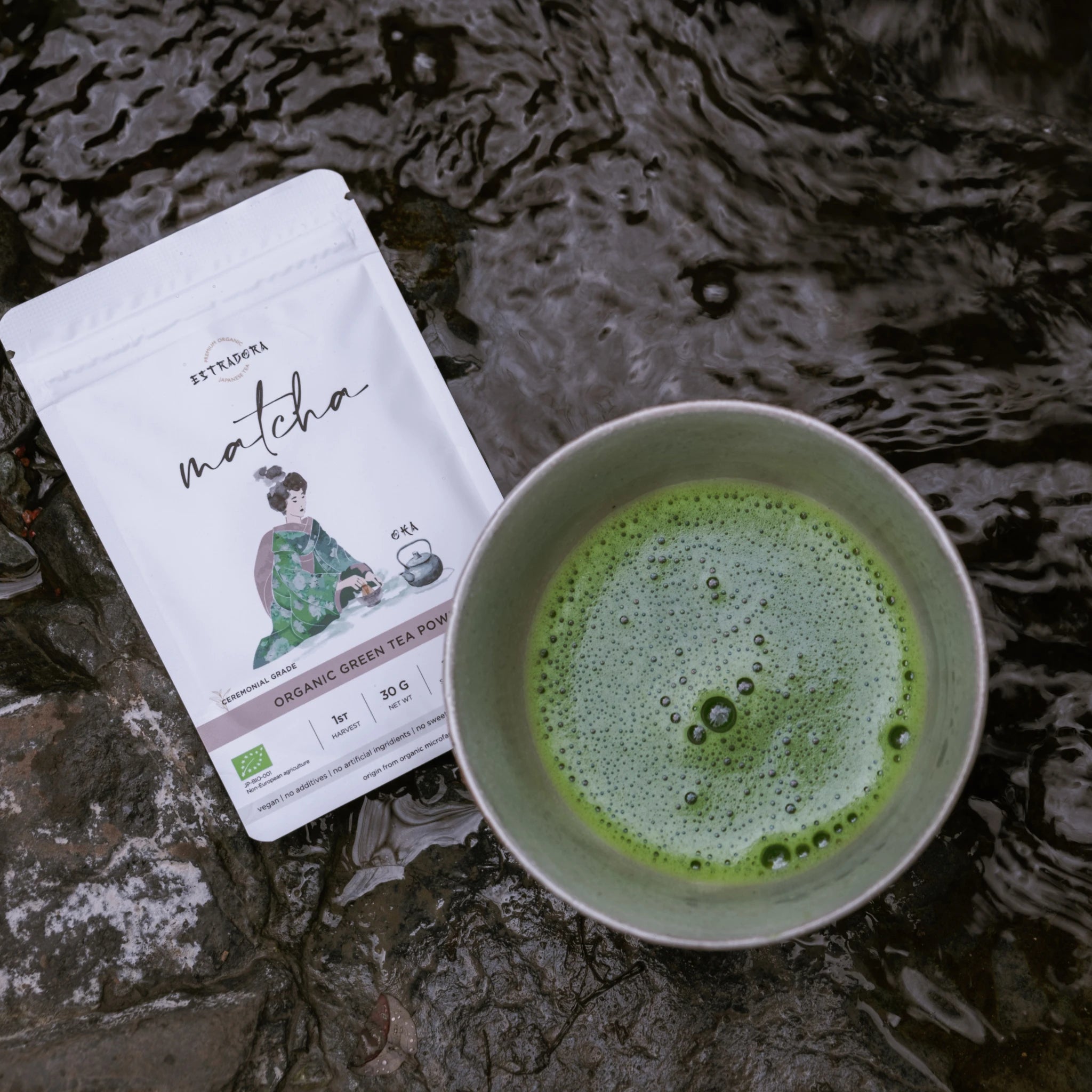 Brewed Matcha Oka Japanese ceremonial green tea in metal cup with Estradora packaging – outdoor nature background