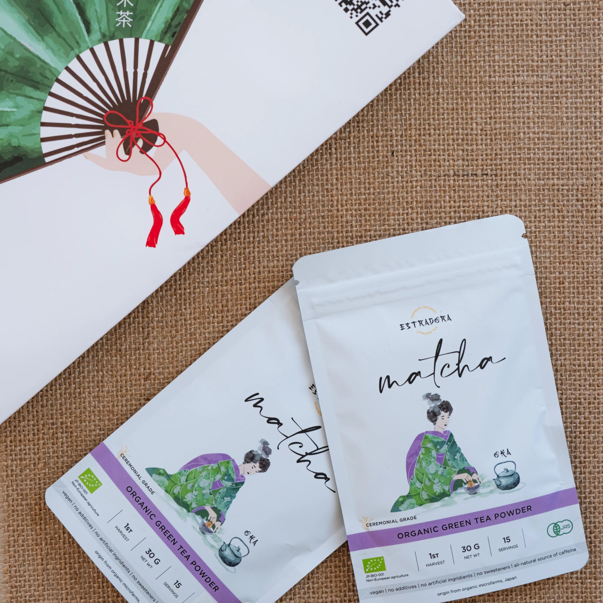 Matcha Oka Japanese ceremonial green tea powder – two Estradora packages on textured background with Japanese fan