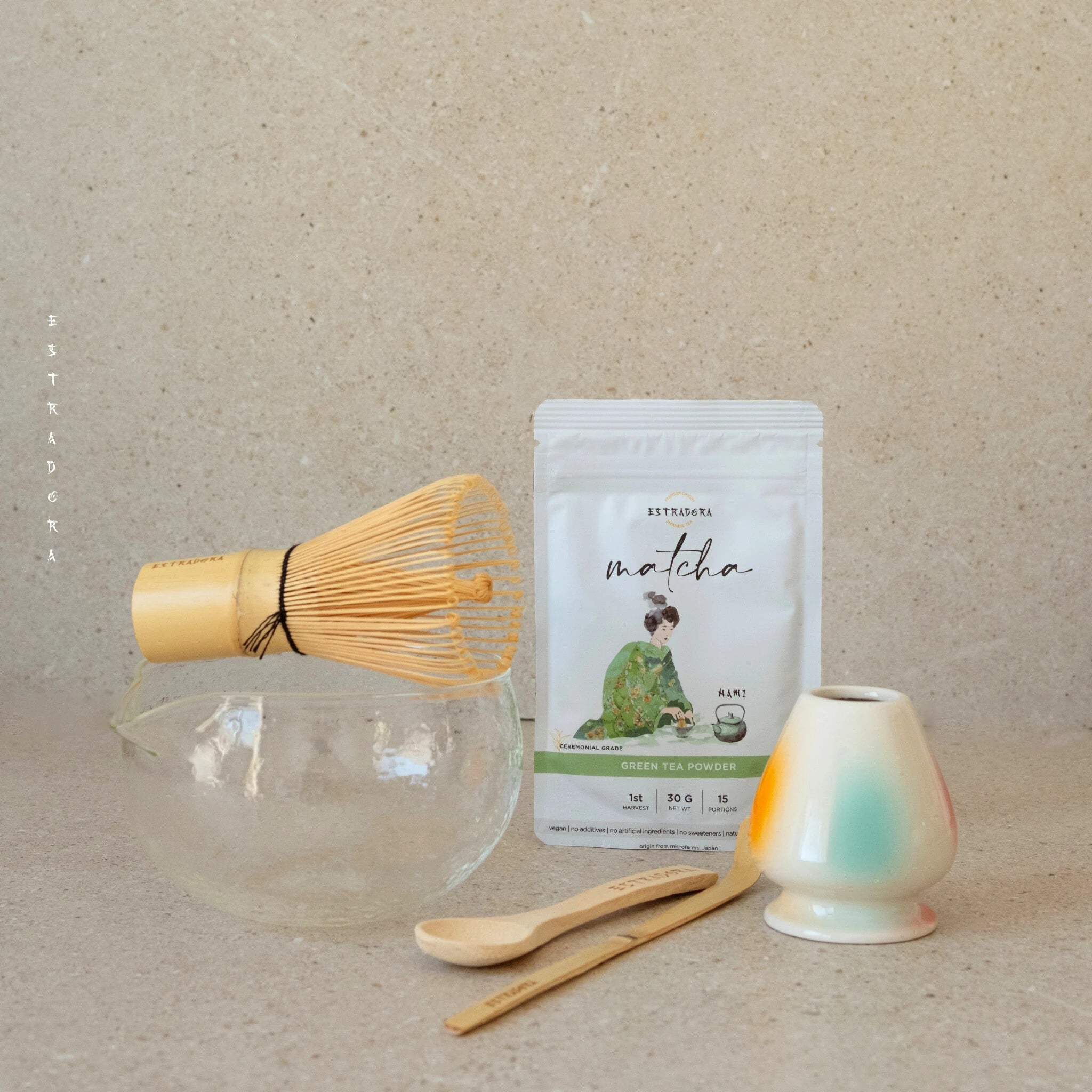 Ceremonial Matcha tea set with bamboo whisk (chasen), whisk holder (naoshi), chashaku scoop, spoon, glass chawan bowl, and Estradora matcha powder Nami